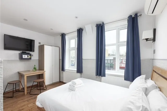 Executive apartment with a double bed, a work desk and a wall-mounted TV