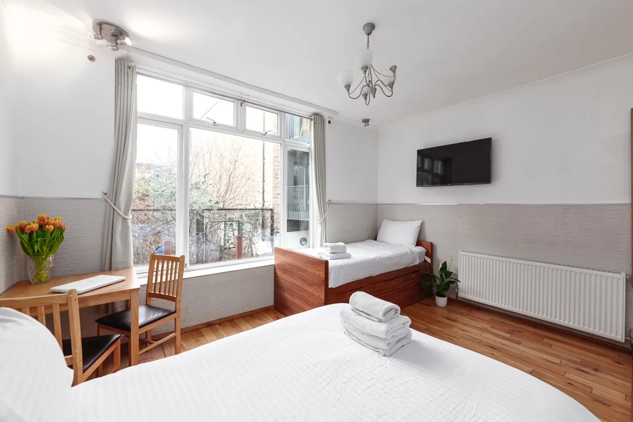 Super Family apartment with a double bed, a single bed, a work desk and a large window